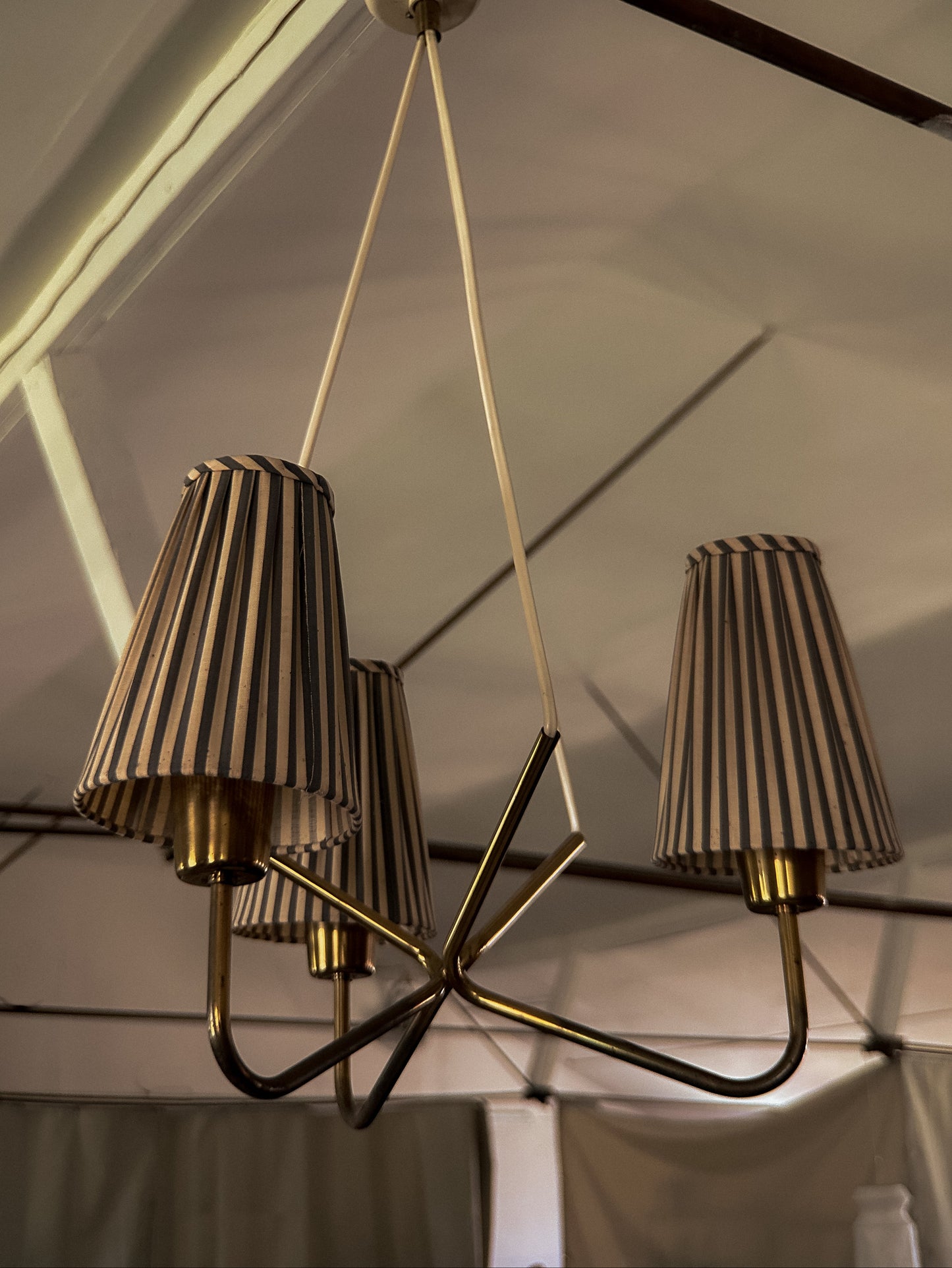 Chandelier with striped lampshades hanging from a ceiling