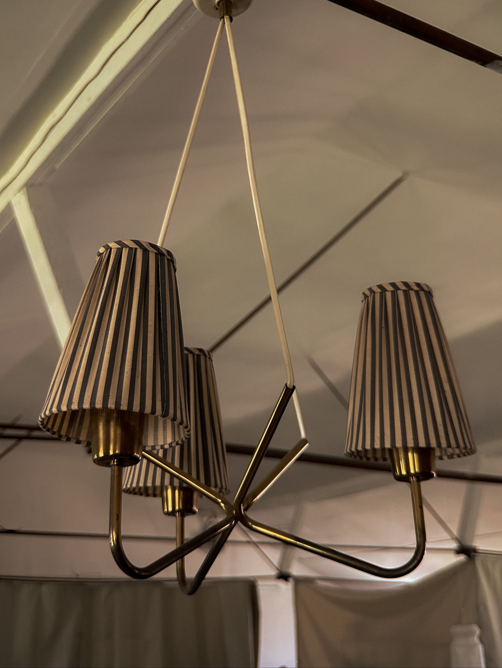 Chandelier with striped lampshades hanging from a ceiling